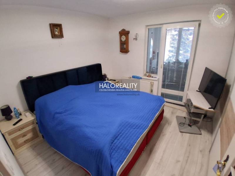 Predaj, rodinný dom Košice Juh - Spálňa s posteľou, televízorom, podlahou s dreveným dekorom a balkónovými dverami v rodinnom dome.