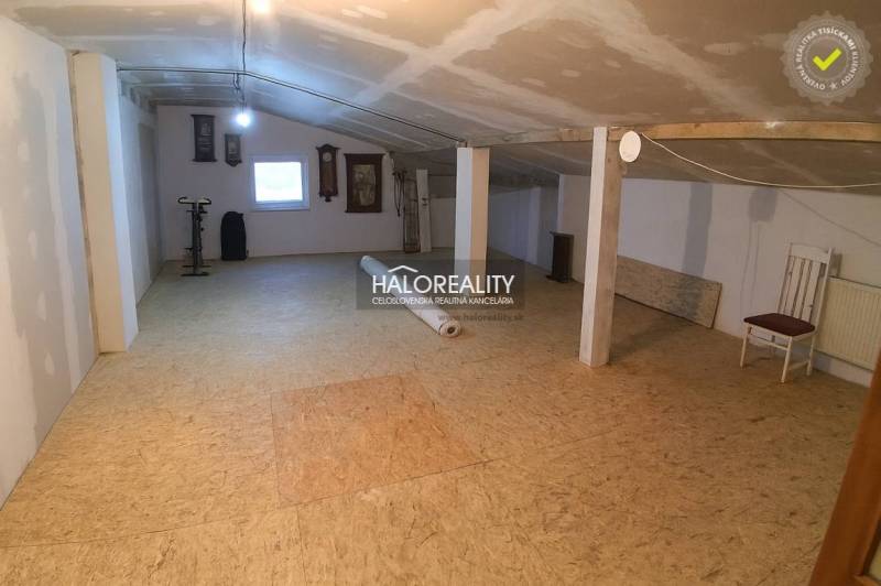 Predaj, rodinný dom Košice Juh - Podkrovný priestor s oknom v rodinnom dome, podlaha s dreveným dekorom, cvičebný bicykel.