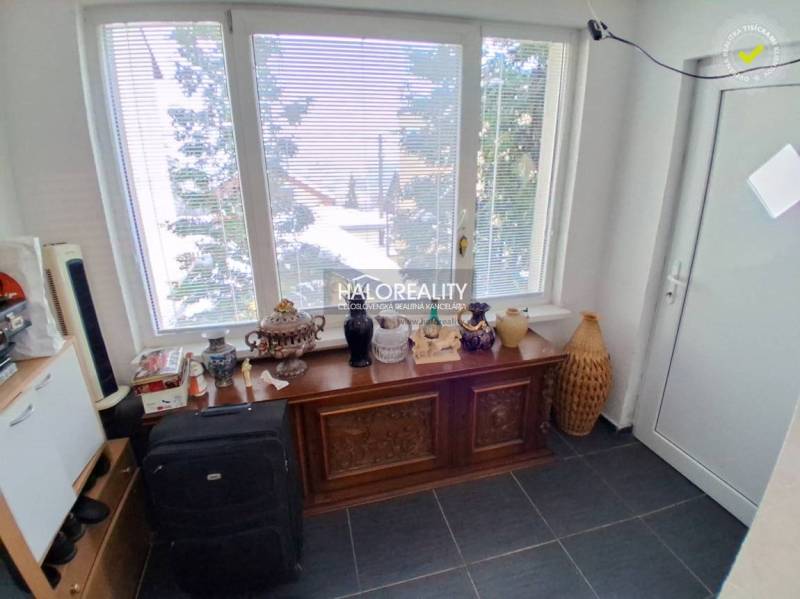 Predaj, rodinný dom Košice Juh - Izba s veľkým oknom, dekoratívnou komodou a rôznymi predmetmi v rodinnom dome.