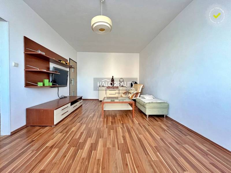 Predaj, trojizbový byt Levice, Rybníky III, po rekon... - Obývacia izba v 3-izbovom byte s podlahou s dreveným dekorom a nábytkom.