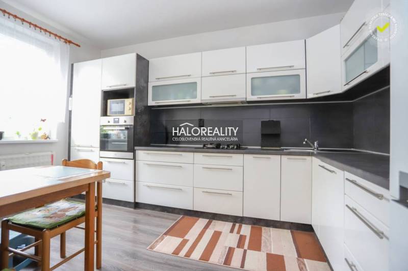 REZERVOVANÉ - Predaj, trojizbový byt Považská Bystri... - Kuchyňa v 3-izbovom byte s bielymi skrinkami a podlahou s dreveným dekorom.