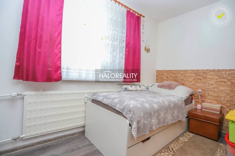 REZERVOVANÉ - Predaj, trojizbový byt Považská Bystri... - Izba v 3-izbovom byte s posteľou, kvetinovým závesom a podlahou s dreveným dekorom.