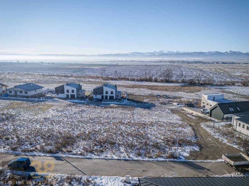 Stavebný pozemok v lokalite Medzi Vodami - Mlynica: Pozemky - bývanie so zasneženými polia a domami, obklopené lesmi a cestami.