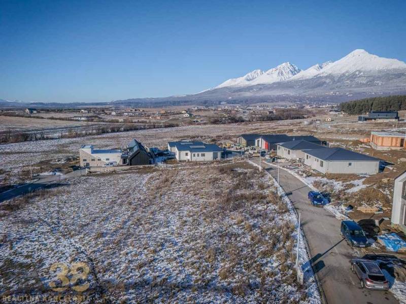 Stavebný pozemok v lokalite Medzi Vodami - Pozemky na bývanie v Mlynici s rozostavanými domami a zasneženou krajinou.