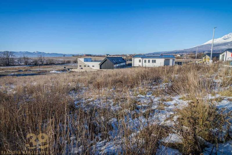 Stavebný pozemok v lokalite Medzi Vodami - Pozemky na bývanie v Mlynici s panoramatickým výhľadom a modernými stavbami v pozadí.