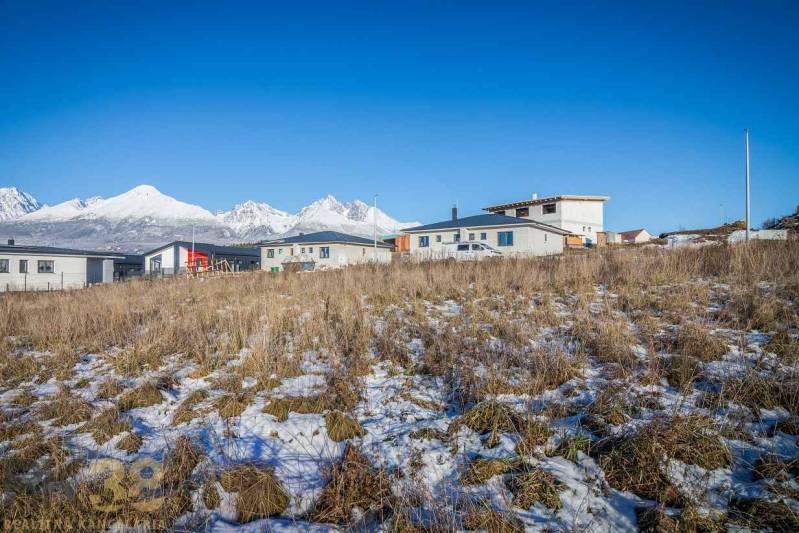 Stavebný pozemok v lokalite Medzi Vodami - Pozemky na bývanie v Mlynici s panoramatickým výhľadom a modernými stavbami v pozadí.