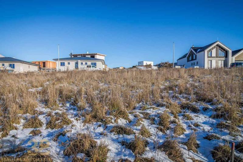 Stavebný pozemok v lokalite Medzi Vodami - Pozemky - bývanie v Mlynici s výhľadom na zasnežené hory a rodinné domy.