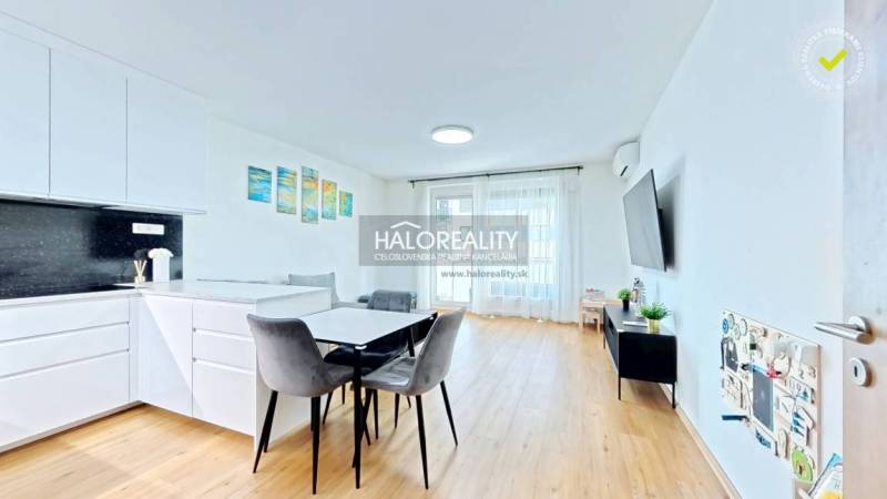 Predaj, dvojizbový byt Bratislava Ružinov, Trnavská ... - Interiér 2-izbového bytu s kuchynským kútom, jedálňou a podlahou s dreveným dekorom.