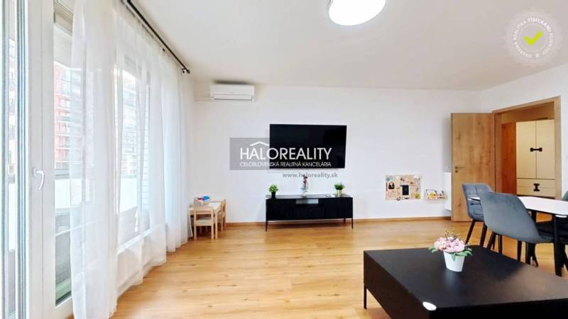 Predaj, dvojizbový byt Bratislava Ružinov, Trnavská ... - Obývacia izba v 2-izbovom byte s podlahou s dreveným dekorom, veľkým oknom a jedálenským stolom.