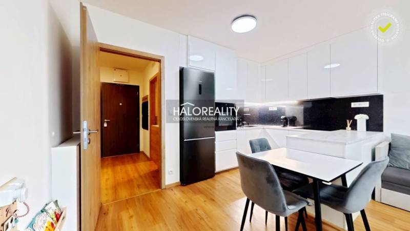 Predaj, dvojizbový byt Bratislava Ružinov, Trnavská ... - Kuchyňa v 2-izbovom byte s jedálenským stolom, vstavanou linkou a podlahou s dreveným dekorom.