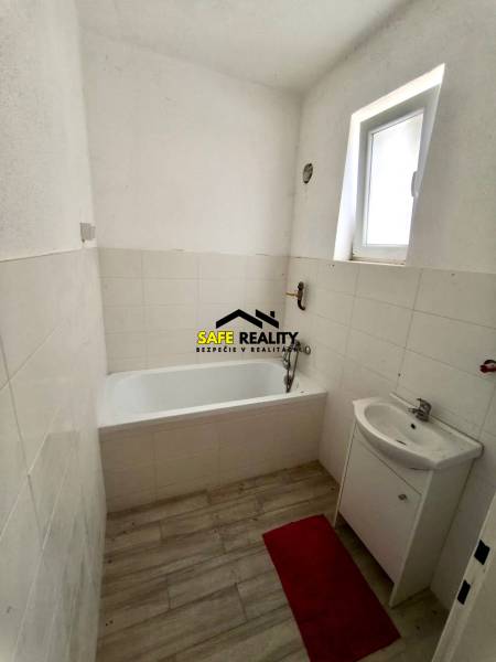 Rodinný dom - Lúčnica nad Žitavou  - Kúpeľňa v rodinnom dome s vaňou, umývadlom a podlahou s dreveným dekorom.