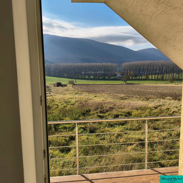 Na predaj – veľkorysý rodinný dom s úžasným výhľadom a pozemkom - Výhľad z rodinného domu v Bukovej ponúka pôsobivé lesy a polia za zábradlím.