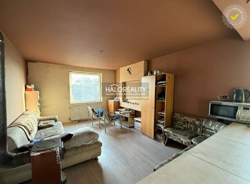 Predaj, rodinný dom Chynorany - EXKLUZÍVNE HALO REALITY - Obývacia izba s pohovkou, nábytkom a kuchynským kútom v rodinnom dome.