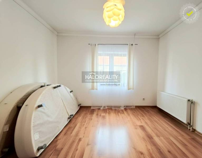 Predaj, rodinný dom Komárno, štvorizbový, čiastočná ... - Izba s podlahou s dreveným dekorom v rodinnom dome, svetlá výzdoba a veľké okno.