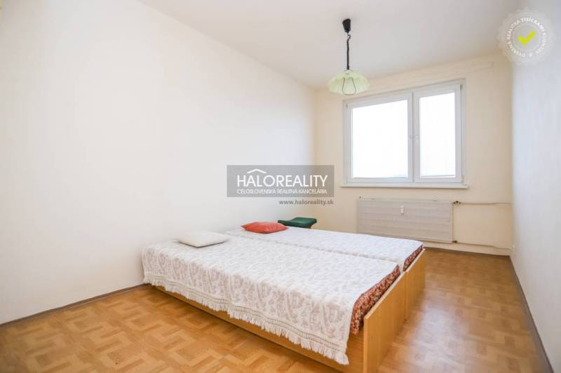 Predaj, trojizbový byt Považská Bystrica, Rozkvet - ... - Spálňa v 3-izbovom byte s podlahou s dreveným dekorom, posteľou pri okne.