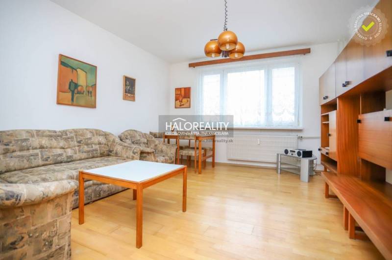 Predaj, trojizbový byt Považská Bystrica, Rozkvet - ... - Obývacia izba v 3-izbovom byte s podlahou s dreveným dekorom, sedačkou a nábytkom.