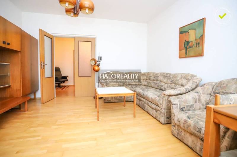 Predaj, trojizbový byt Považská Bystrica, Rozkvet - ... - Obývacia izba 3-izbového bytu s pohovkou, stolom a podlahou s dreveným dekorom.