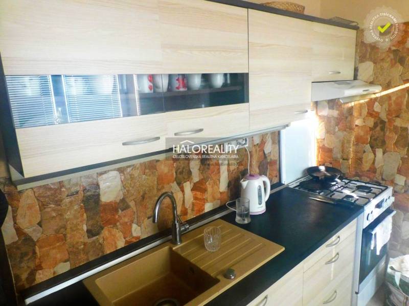 Predaj, dvojizbový byt Topoľčany, Centrum - Izba v 2-izbovom byte s podlahou s dreveným dekorom, televízorom a vstavanými skriňami.