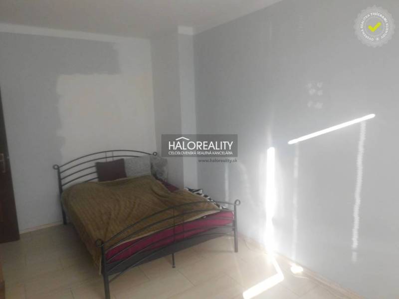 Predaj, dvojizbový byt Topoľčany, Centrum - Spálňa s kovovou posteľou a bielymi stenami v 2-izbovom byte.