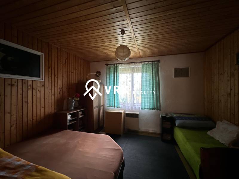 RODINNÝ DOM - CHALUPA, KALŠA - Izba s dreveným obkladom a posteľami v rodinnom dome.