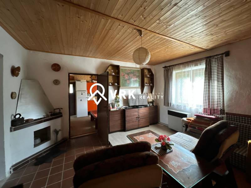 RODINNÝ DOM - CHALUPA, KALŠA - Obývacia izba v rodinnom dome s dreveným dekorom stropu a útulným nábytkom.