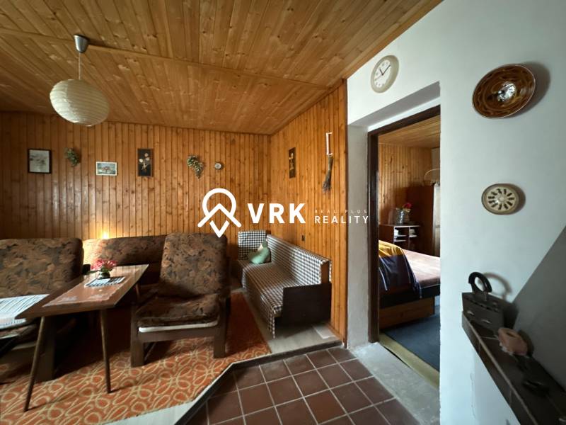 RODINNÝ DOM - CHALUPA, KALŠA - Interiér rodinného domu s dreveným obkladom a pohodlným nábytkom s retro dekoráciami.