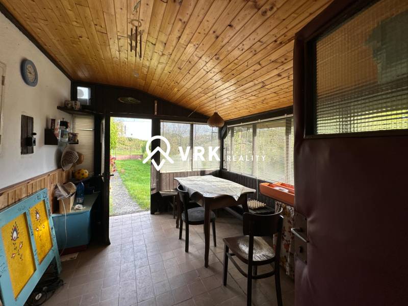 RODINNÝ DOM - CHALUPA, KALŠA - Interiér rodinného domu s podlahou s dreveným dekorom, jedálenským stolom a výhľadom do záhrady.