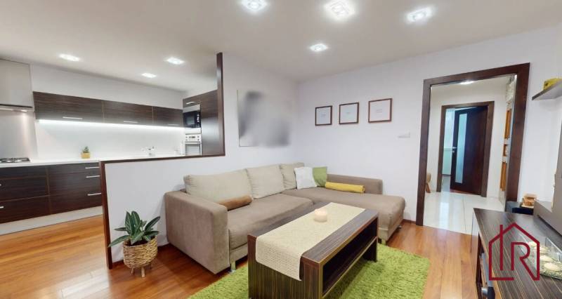 KH-1032, 3 izbový byt Košice, Dargovských hrdinov, ul. Tokajícka - Obývacia izba v 3-izbovom byte s podlahou s dreveným dekorom a pohodlnou sedacou súpravou.