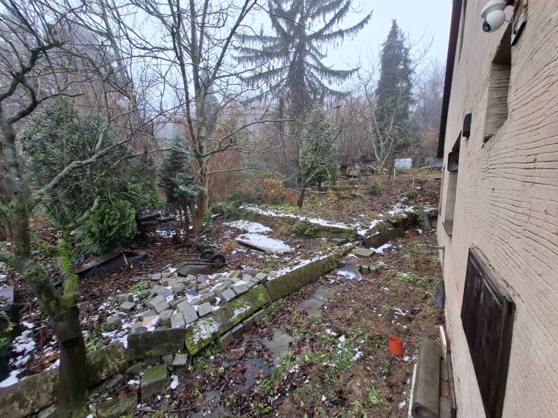 Predaj rodinného domu s pozemkom v  lukratívnej časti mesta Bratislava - Záhrada pri rodinnom dome na Búdkovej ulici v Bratislava - Staré Mesto, stromy a kamene.