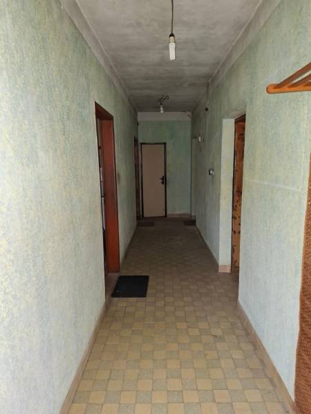 Predaj rodinného domu s pozemkom v  lukratívnej časti mesta Bratislava - Chodba v rodinnom dome so svetlo zelenými stenami, dlažbou a jednoduchým osvetlením.