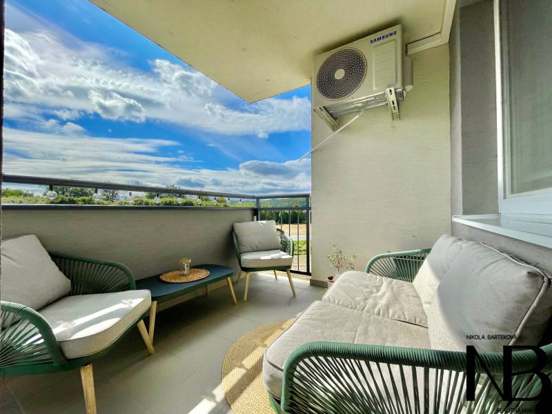 Na predaj štýlový 2-izbový byt s loggiou a parkovaním – TN, Na Pažiti - Útulný balkón s posedením, výhľadom a klimatizačnou jednotkou v 2-izbovom byte.