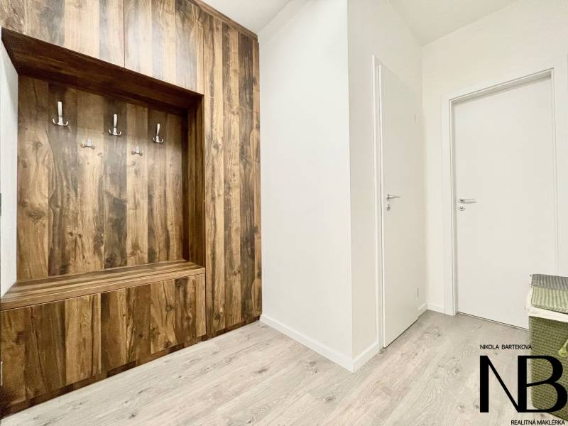 Na predaj štýlový 2-izbový byt s loggiou a parkovaním – TN, Na Pažiti - Vstupná hala 2-izbového bytu s podlahou s dreveným dekorom a vstavanou skriňou.