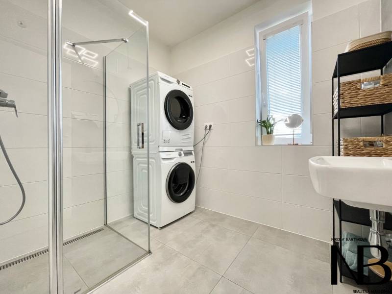 Na predaj štýlový 2-izbový byt s loggiou a parkovaním – TN, Na Pažiti - Kúpeľňa v 2-izbovom byte so sprchovým kútom a práčkou so sušičkou.