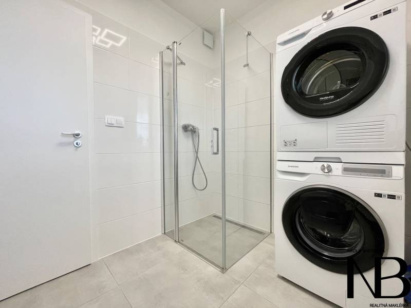 Na predaj štýlový 2-izbový byt s loggiou a parkovaním – TN, Na Pažiti - Kúpeľňa v 2-izbovom byte s práčkou, sušičkou a sprchovým kútom.