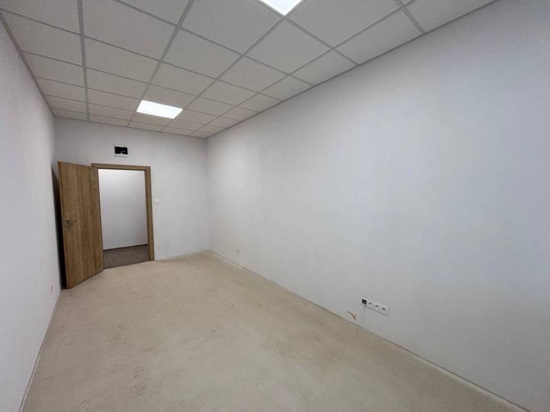 Prenájom nových kancelárskych priestorov a skladov na Teplickej ulici  - Interiér kancelárie s bielymi stenami, podhľadovým stropom a otvorenými dverami.