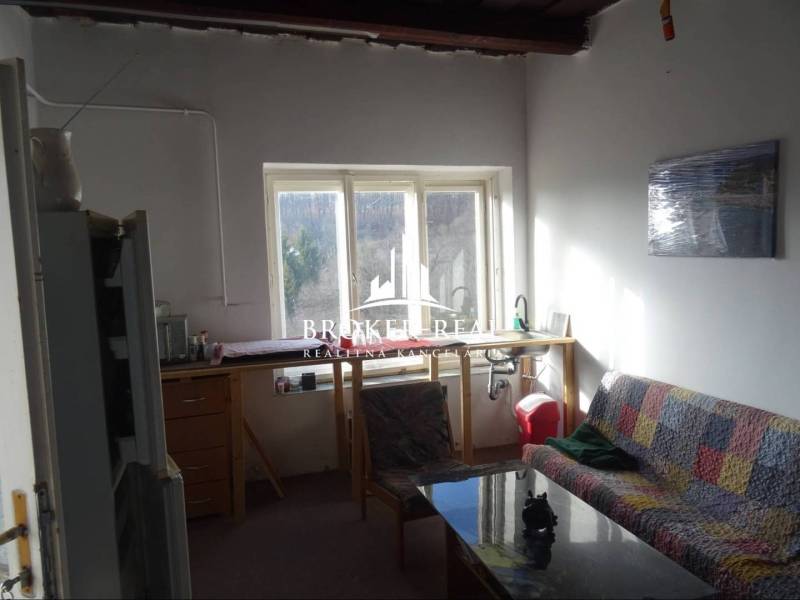 Rodinný dom Rudabanya, Maďarsko - Obývacia izba s gaučom a výhľadom von, Rodinný dom s jednoduchým zariadením.