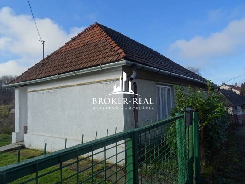 Rodinný dom Rudabanya, Maďarsko - Rodinný dom v Rudabányi s bielou fasádou a šikmou strechou za zeleným plotom.