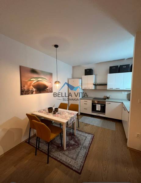 PRENÁJOM - Moderný 2 izbový byt, Galanta-GALA Residence - Kuchyňa a jedáleň v 2-izbovom byte s podlahou s dreveným dekorom.