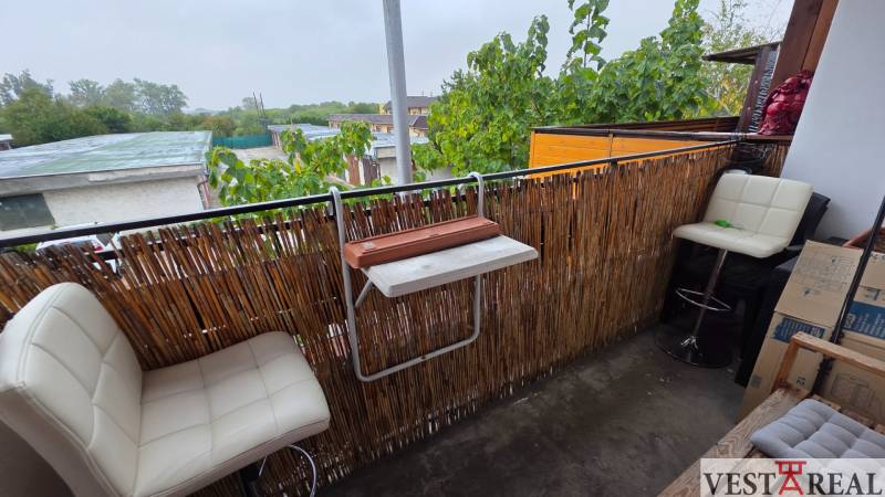 Na prenájom 3 izbový byt z balkónom a parkovacím miestom - Balkón 3-izbového bytu v Galante s moderným zábradlím a bielymi barovými stoličkami.