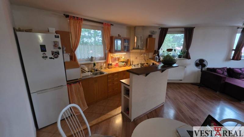 Na prenájom 3 izbový byt z balkónom a parkovacím miestom - Kuchyňa v 3-izbovom byte s podlahou s dreveným dekorom a jedálenským stolom.