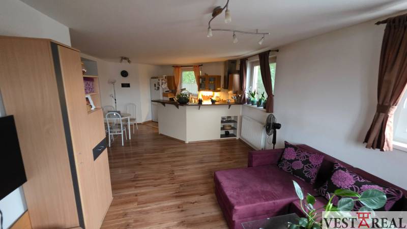 Na prenájom 3 izbový byt z balkónom a parkovacím miestom - Obývacia izba s kuchyňou v 3-izbovom byte s podlahou s dreveným dekorom.