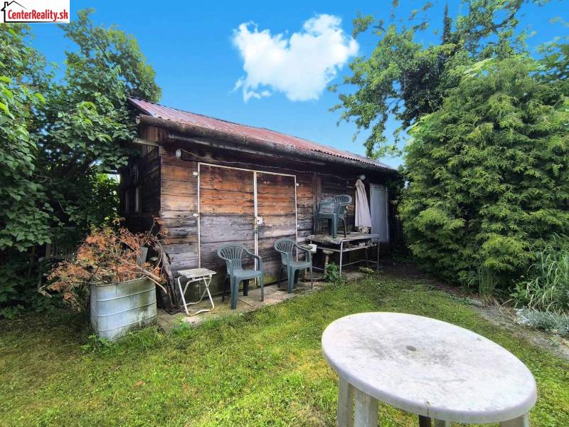 ‼️ RODINNÝ DOM V TICHEJ LOKALITE NA PREDAJ, NOVÁKY okr. PRIEVIDZA ‼️ - Drevená chatka s plastovými stoličkami v záhrade rodinného domu v Novákoch.