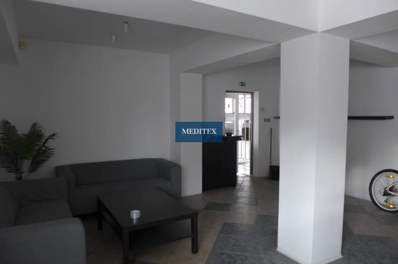 Sklad na prenájom o ploche 288 m2-438 m2 + kancelárie a vzorkovňa - Obývací priestor so sivými pohovkami, stolíkom a dlaždicovou podlahou v Skladoch a halách.