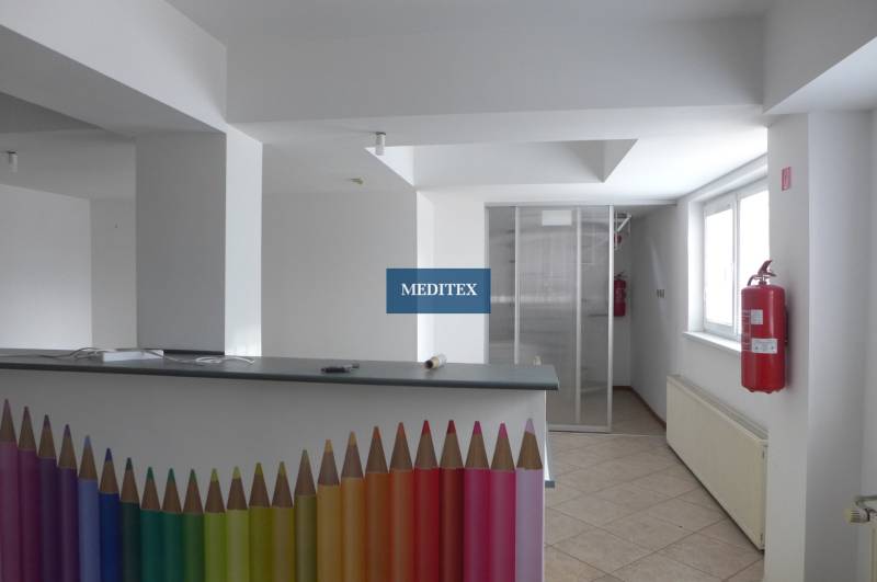 Sklad na prenájom o ploche 288 m2-438 m2 + kancelárie a vzorkovňa - Interiér Sklady a haly s recepčným pultom zdobeným farebnými ceruzkami a požiarnym hydrantom.