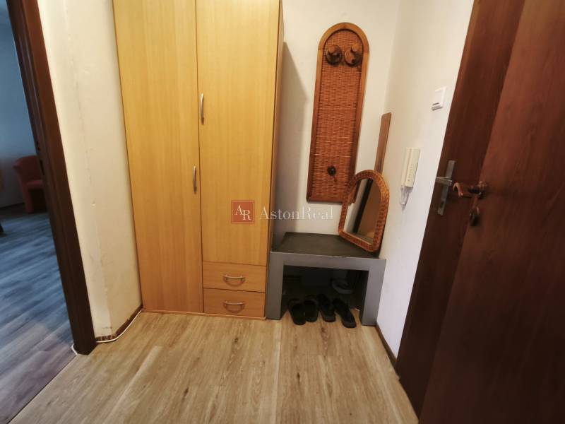 PREDAJ: 1i byt 30m2 - BAURING - FONČORDA - Orenburská ul. - Predsieň 1-izbového bytu s policou, zrkadlom, skriňou a podlahou s dreveným dekorom.