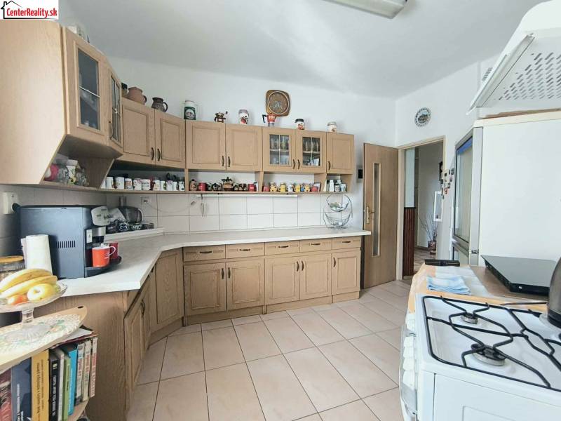 ‼️RODINNÝ DOM S KRÁSNYM POZEMKOM NA PREDAJ,KOLAČNO okr. PARTIZÁNSKE ‼️ - Kuchyňa v rodinnom dome s drevenými skrinkami a keramickou dlažbou.