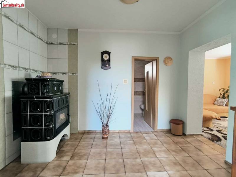 ‼️RODINNÝ DOM S KRÁSNYM POZEMKOM NA PREDAJ,KOLAČNO okr. PARTIZÁNSKE ‼️ - Interiér rodinného domu so zelenými kachľami, kachľovou pecou a dlažbou.