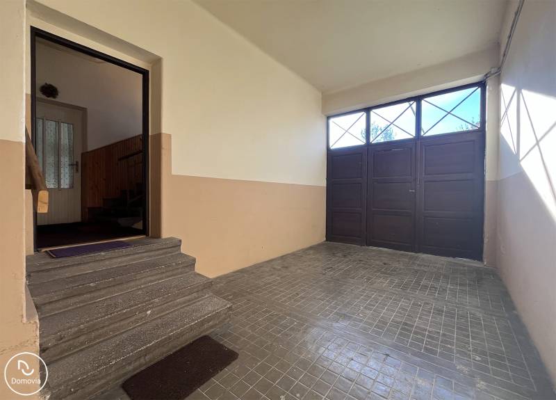 Exkluzívne | Na predaj 5i byt s garážou a záhradou v centre Ružomberka - Vstupná hala s garážovými dverami v 5 a viac izbovom byte, schody vedú do interiéru.