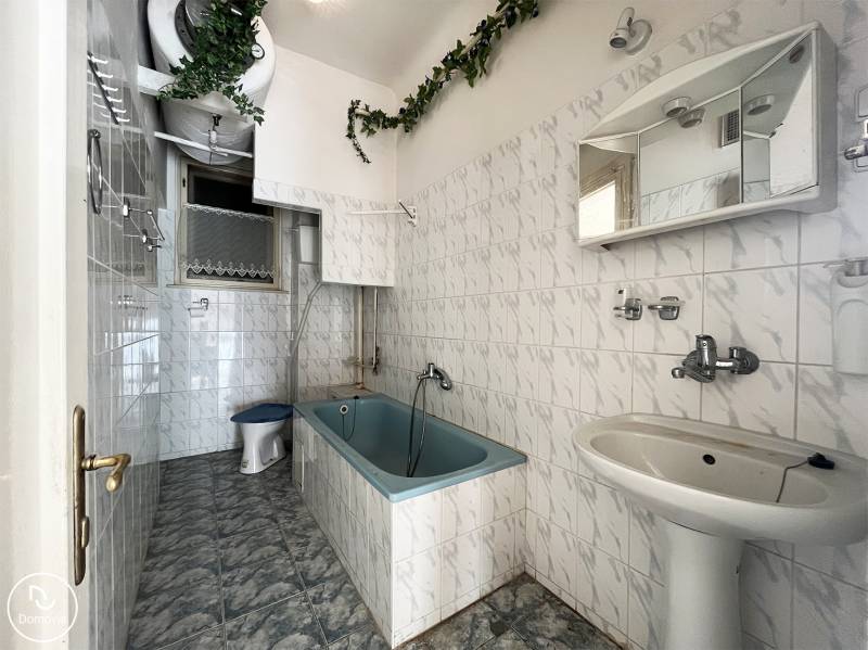 Exkluzívne | Na predaj 5i byt s garážou a záhradou v centre Ružomberka - Kúpeľňa s vaňou, bielymi kachličkami a zelenou dekoráciou v 5 a viac izbovom byte.