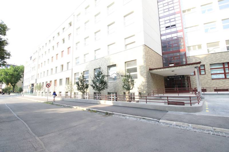 ŠIKOVNÁ GARSÓNKA na PRENÁJOM v CENTRE MESTA na BEZRUČOVEJ ul. - Budova na Bezručovej ulici v Bratislave - Starom Meste s rampou a stromami.